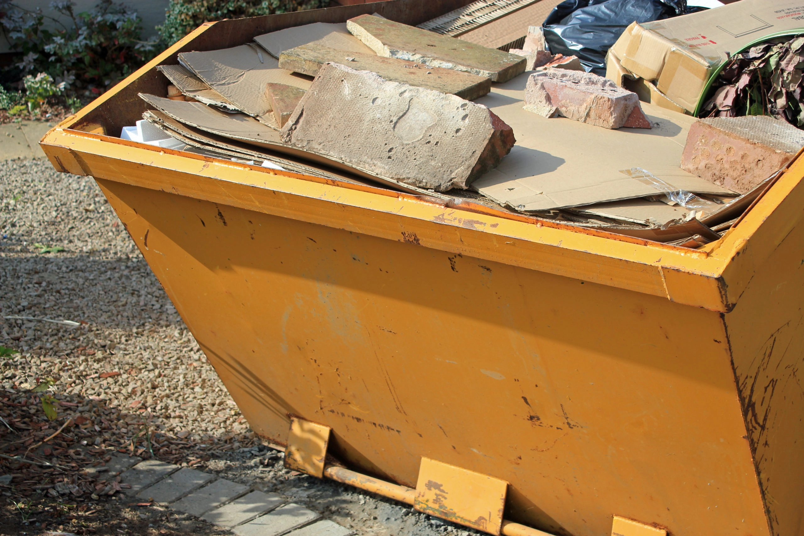 Yellow skip containing construction material