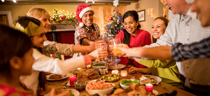 A family clink their glass to say cheers during Christmas dinner