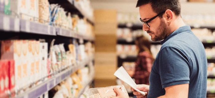 A man consults his shopping list in a food shop