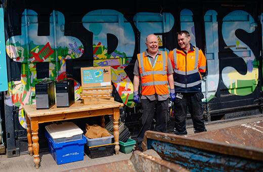 Two IT reuse colleagues standing next to the Reuse depository box
