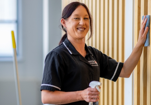 Woman cleaning wall and smiling