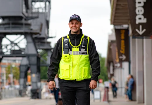 Security guard in hi-visibility clothing walking