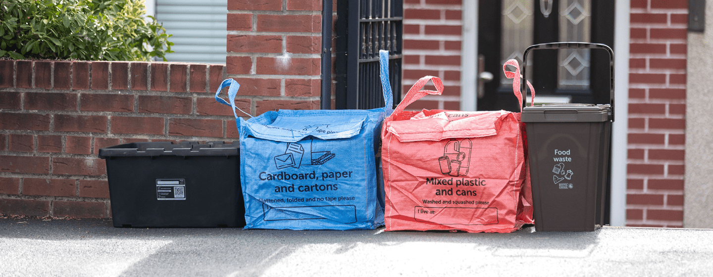 Recycling containers lined up neatly outside a house