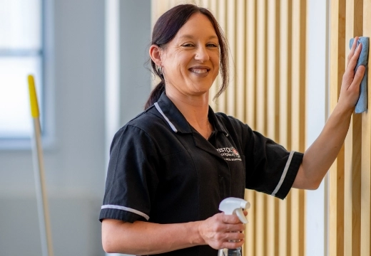 Woman cleaning wall and smiling