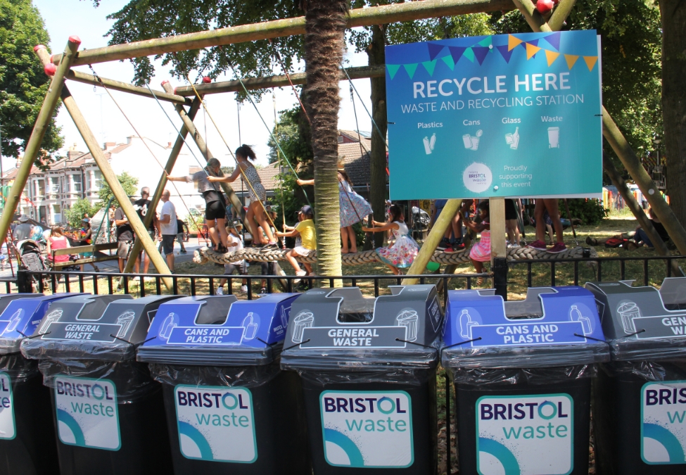 Assorted recycling bins in front of a children's park