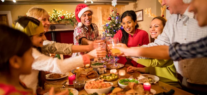 A family clink their glass to say cheers during Christmas dinner