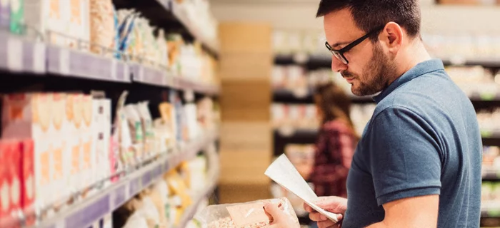 A man consults his shopping list in a food shop