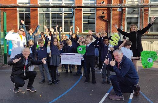 Class of 30 children holding a cheque they won for taking the Waste Nothing Schools Challenge