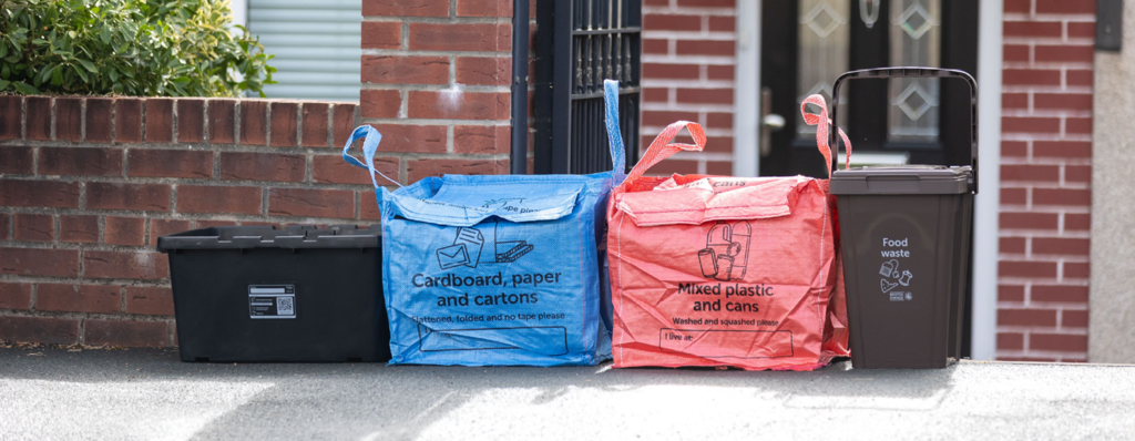 Recycling containers lined up neatly outside a house
