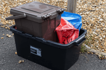 Recycling containers stacked outside of someone's house