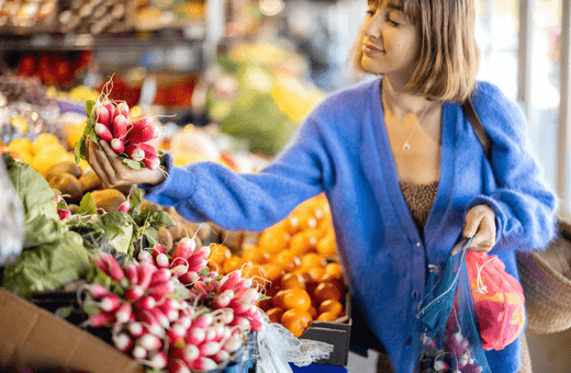 A woman shopping for food using reusable bags