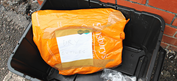 A bag of old clothes inside a recycling box