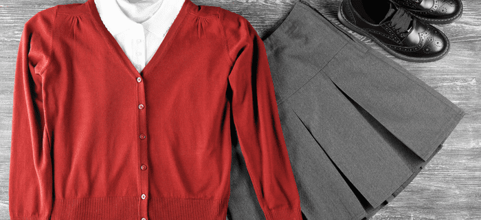 A red school uniform jumper and grey skirt