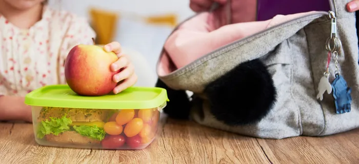 A school bag and lunch box in a table