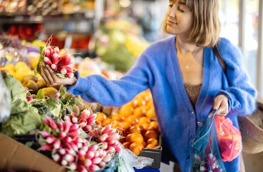 A woman shopping for food using reusable bags
