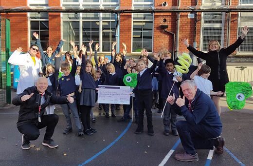 Class of 30 children holding a cheque they won for taking the Waste Nothing Schools Challenge