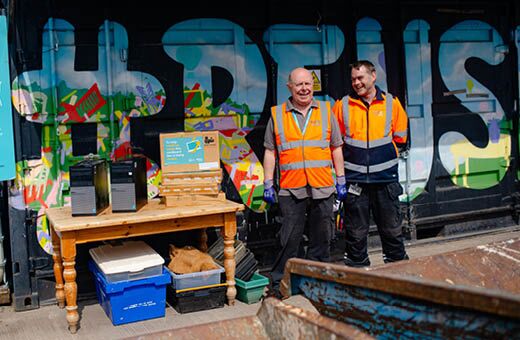 Two IT reuse colleagues standing next to the Reuse depository box