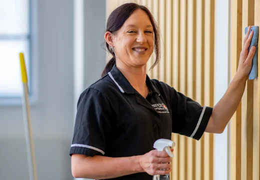 Woman cleaning wall and smiling