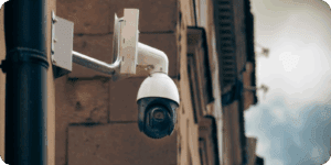 CCTV camera on a brick wall behind