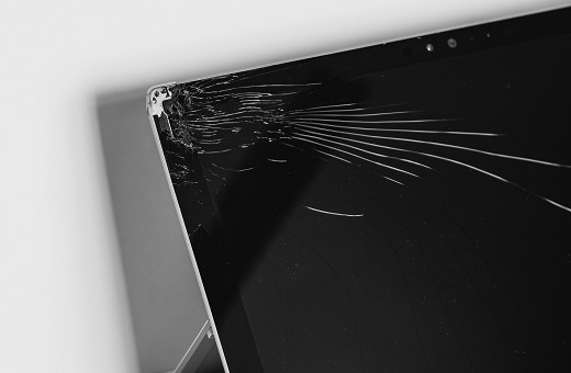 Image of a broken laptop screen dented in the corner