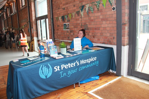 St Peter's Hospice volunteer sitting at a table at a reuse event