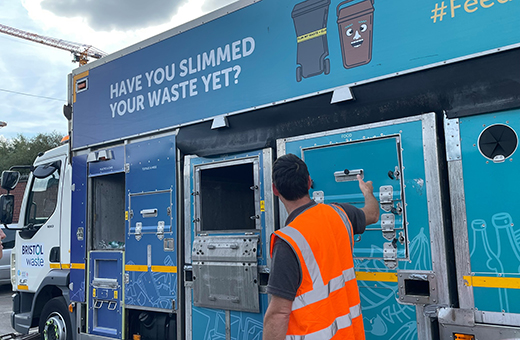 bristol waste community engagement officer pointing at a blue bristol waste recycling truck