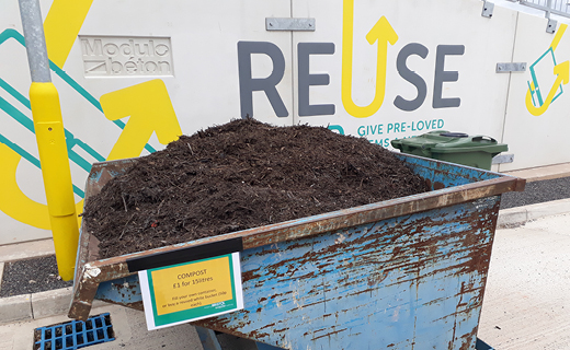 A big blue bin with compost outside the Reuse Shop