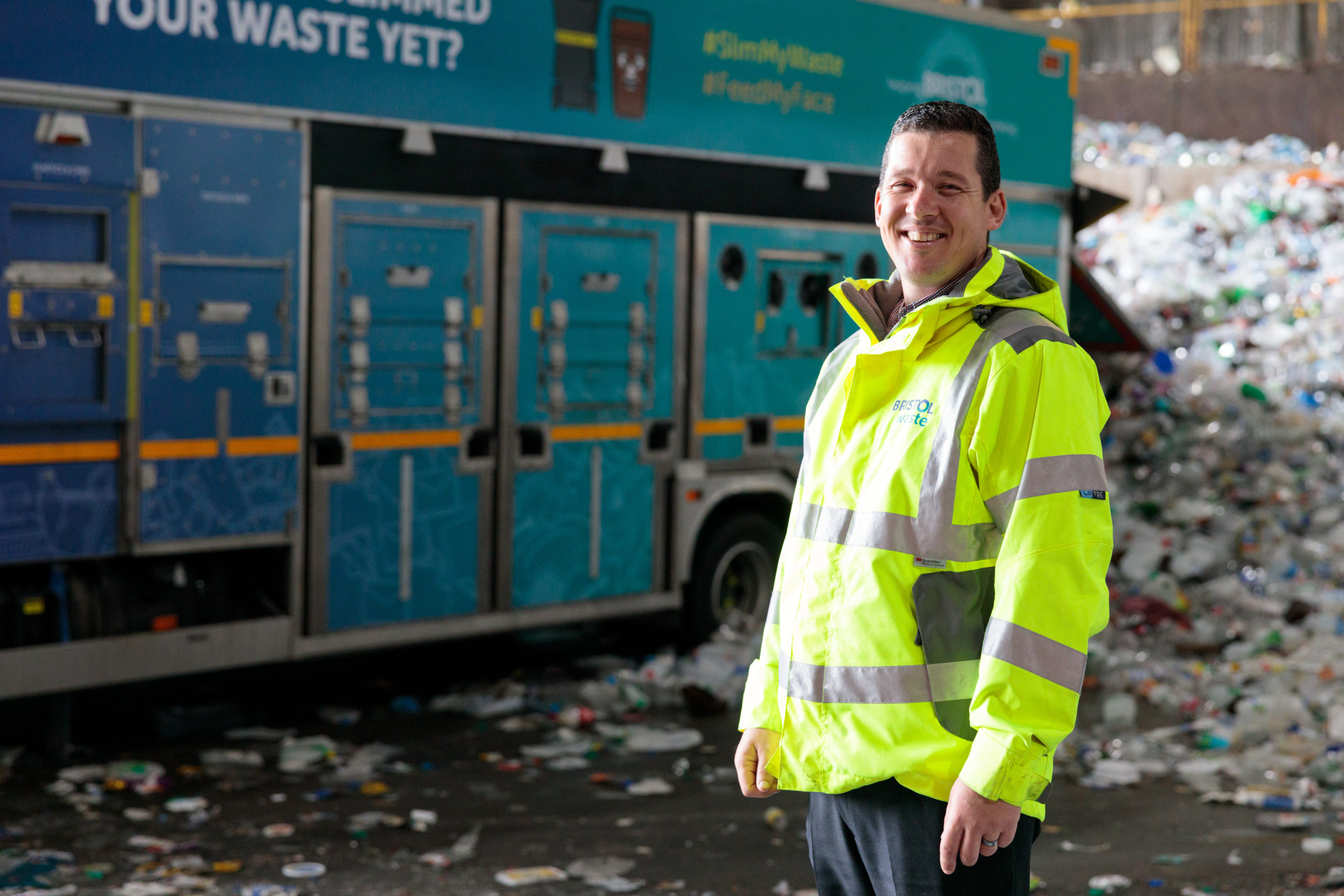 Bristol Waste male employee stoof in front of household recycling truck