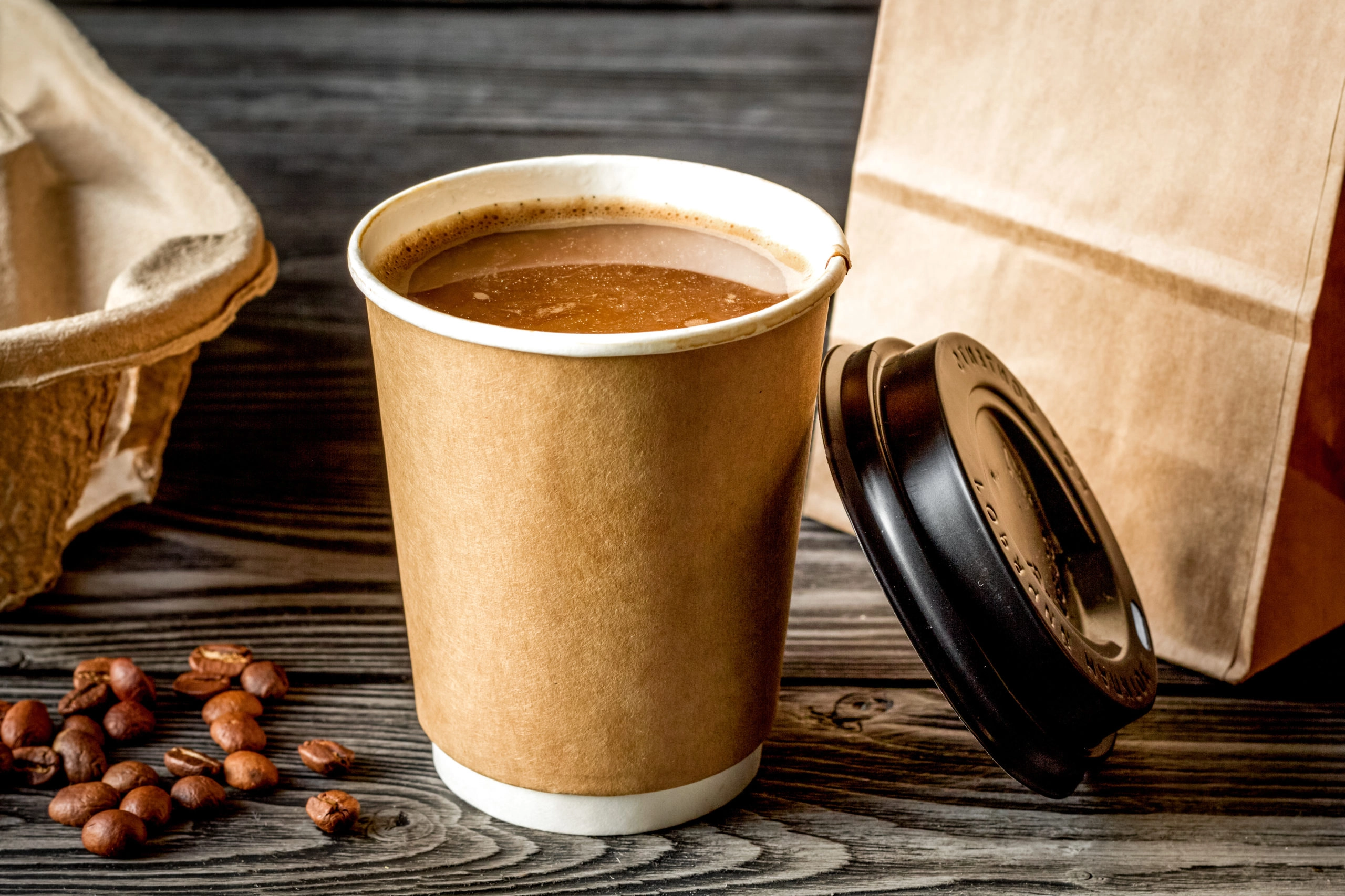 a-person-holding-a-cup-of-coffee-in-front-of-a-yellow-background-with