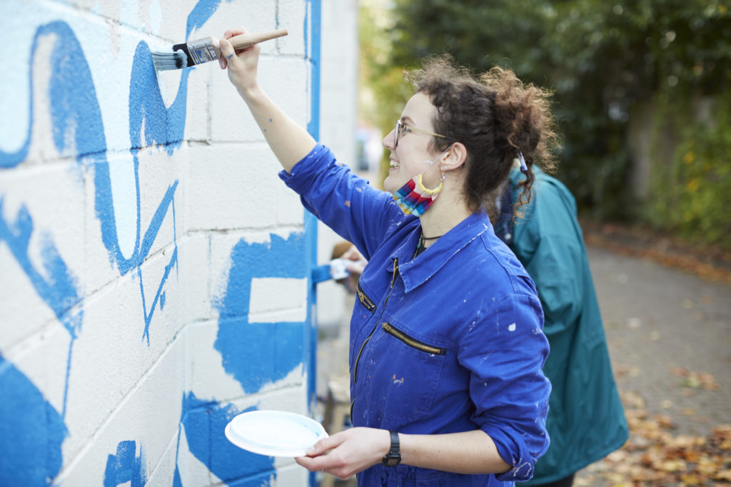 Artist Beth Breeden painting the wall of Easton leisure centre.