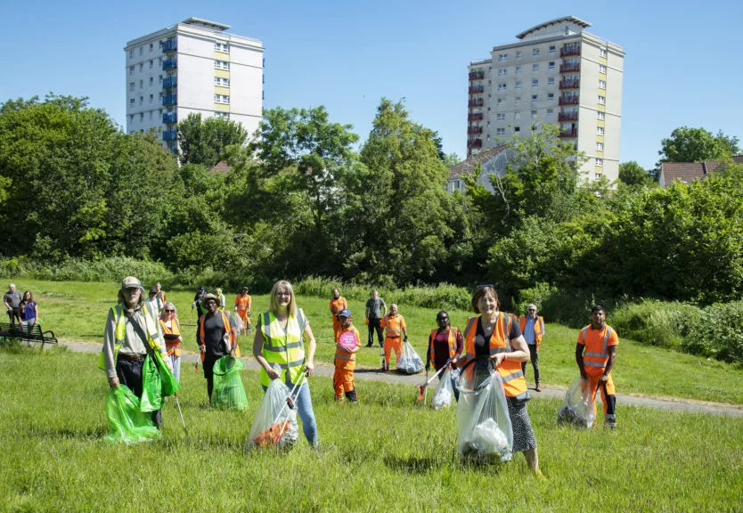 A team of Big Tidy litter picking volunteers pose in for the camera in a park in the sunshine.