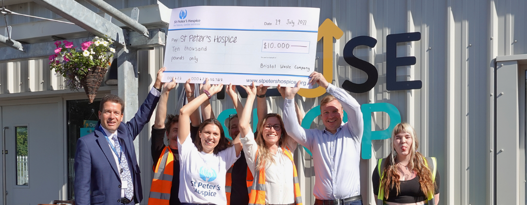 A group of people hold a giant cheque for St Peter's Hospice above their heads