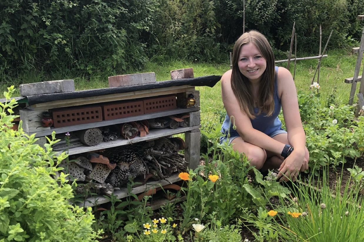 Alex on her allotment next to her DIY bug hotel