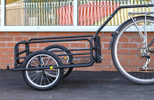 A photo of a bike trailer attached to the back wheel of a bike