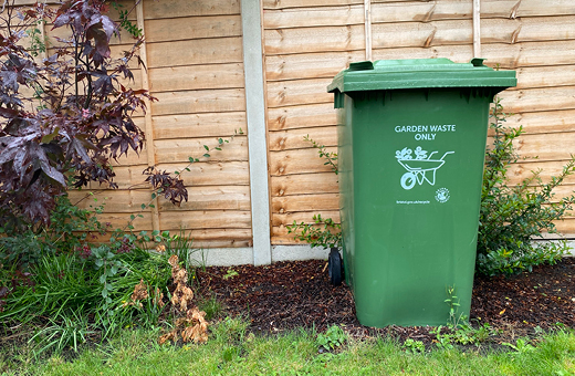 Garden waste wheelie bin in a garden