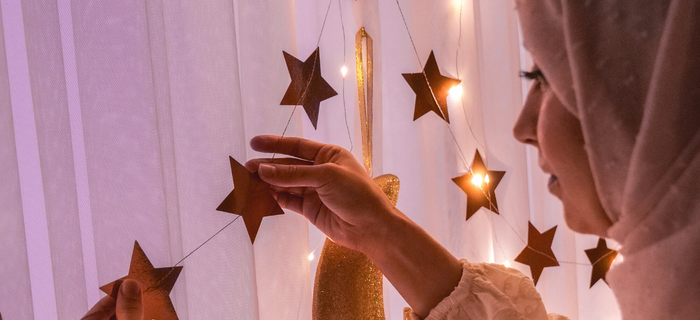 A woman hangs paper stars for Ramadan