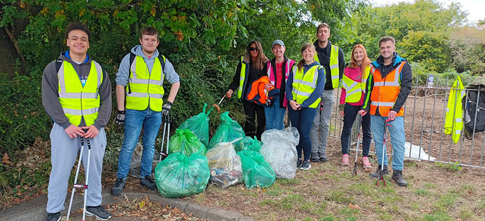 Three people on a litter pick in some gardens