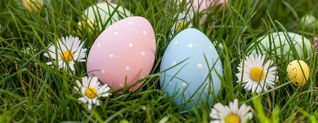 Hand painted eggs lying in the grass for an Easter egg hunt.