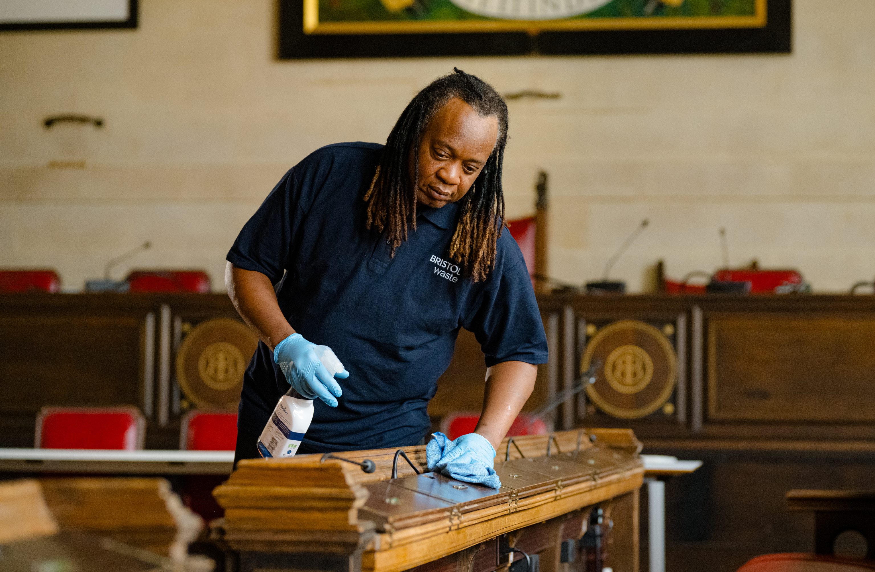 A cleaner cleans the wooden surfaces in Bristol's City Hall