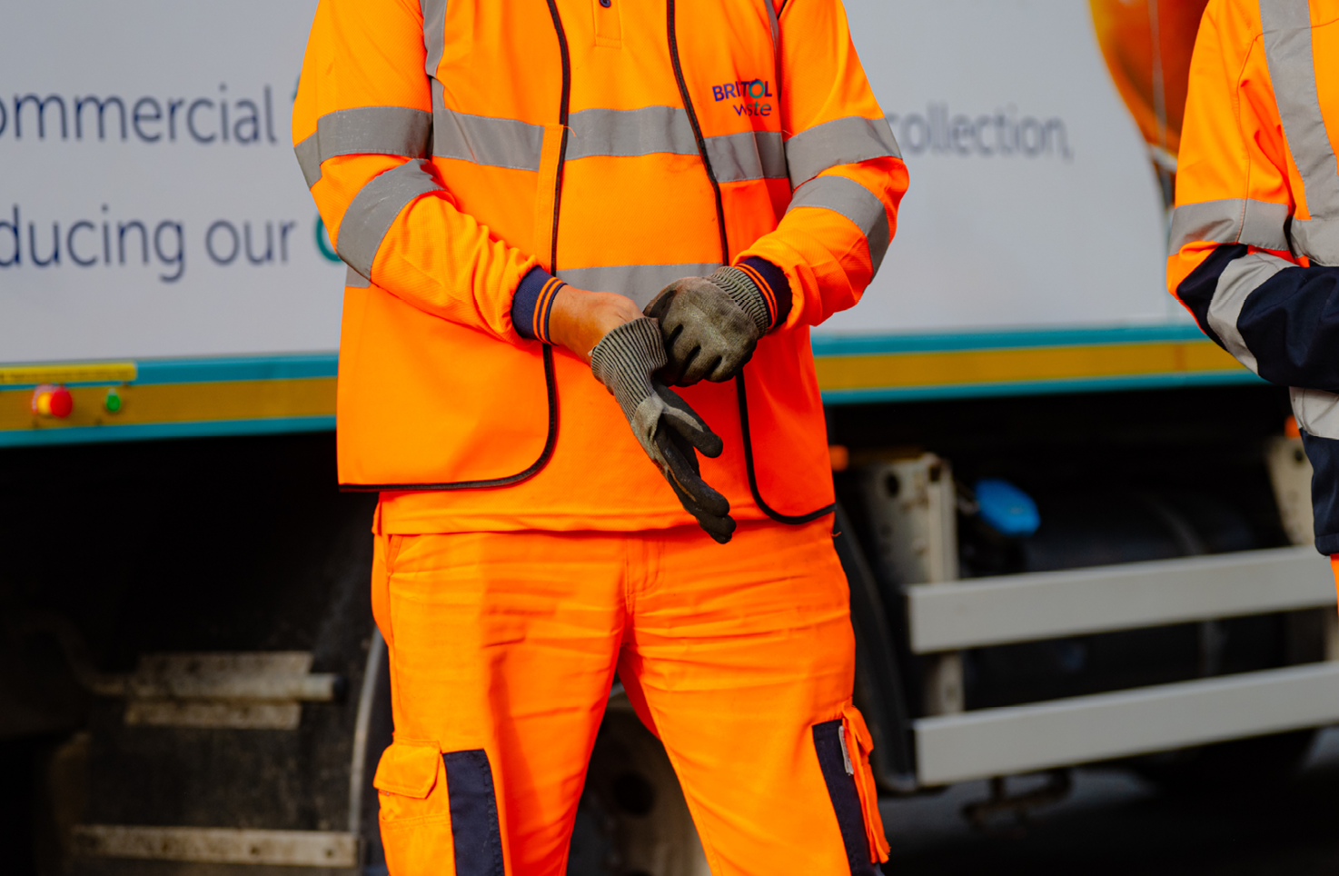 A Bristol Waste person in hi-vis is putting their gloves on