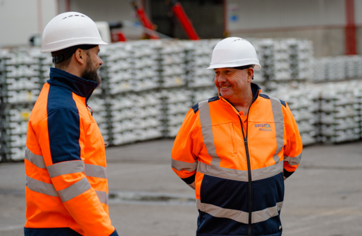 Two people speaking wearing hardhats.