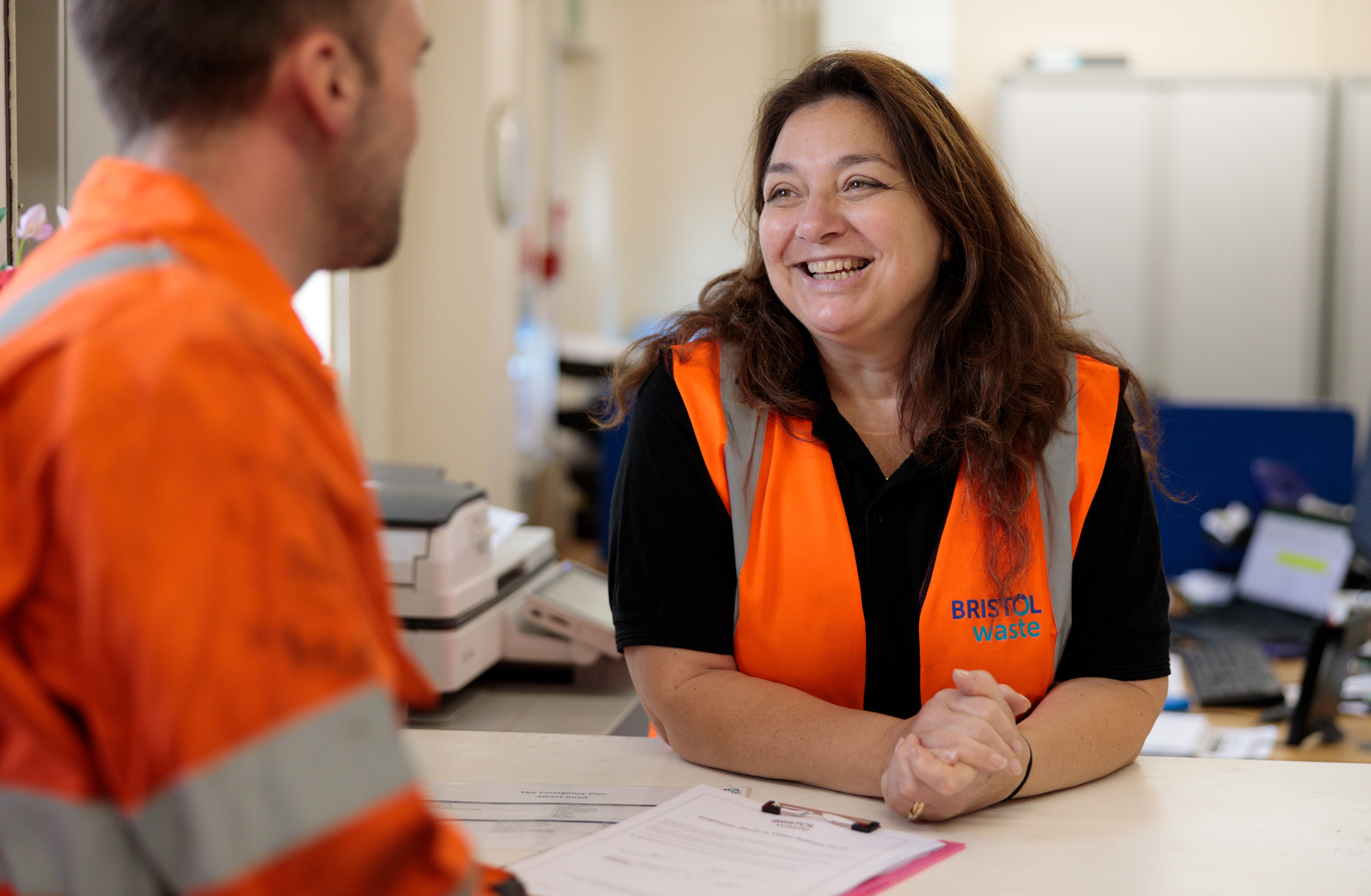 A smiling Bristol Waste team member is helping someone with a query.