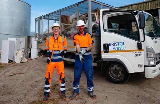 Two crews members standing next to a bulk waste collections truck