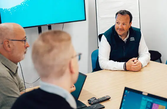 The people sitting in a board room discussing commercial sales