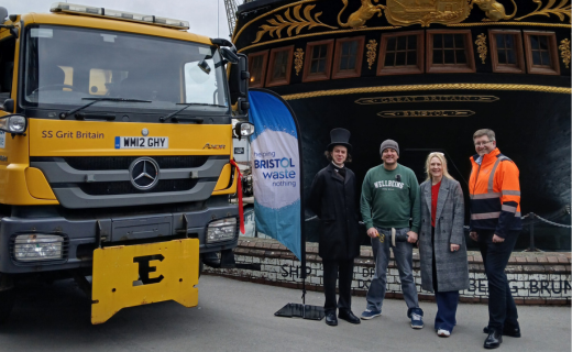 A group of people standing next to a gritter and the SS Great Britain.