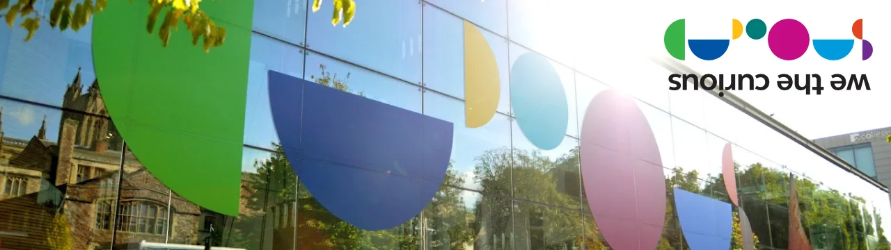 Outside of building with colours on the building and we the curious logo