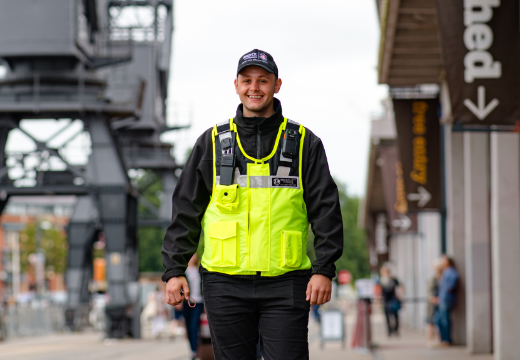 Security guard in hi-visibility clothing walking