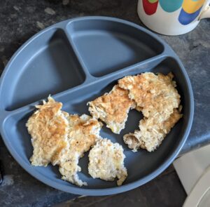 Caramelised oat and banana pancakes in a child's bowl on a kitchen worktop