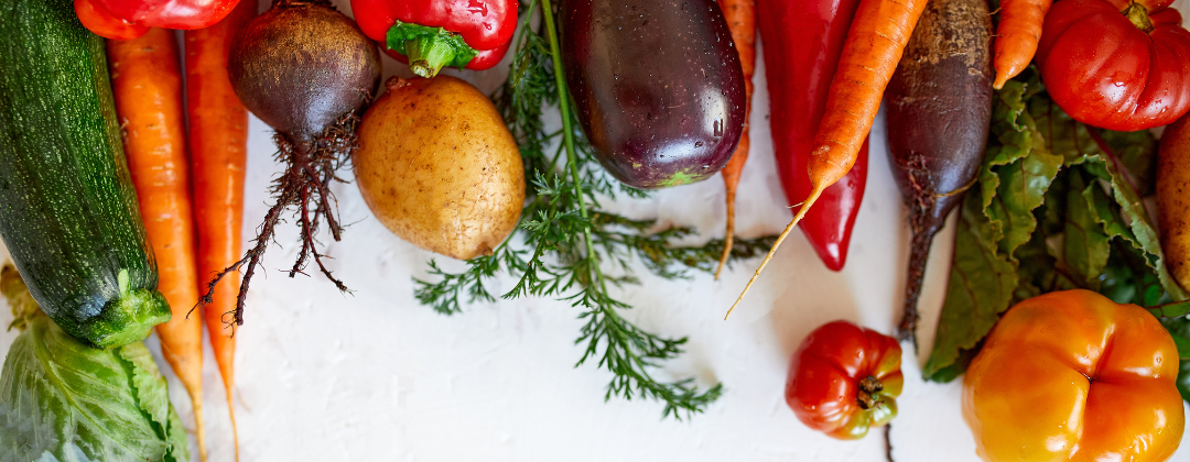 Fresh, colourful vegetables lined up on a white background