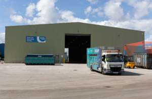 The Avonmouth materials recycling facility in the sunshine with a recycling truck in the foreground